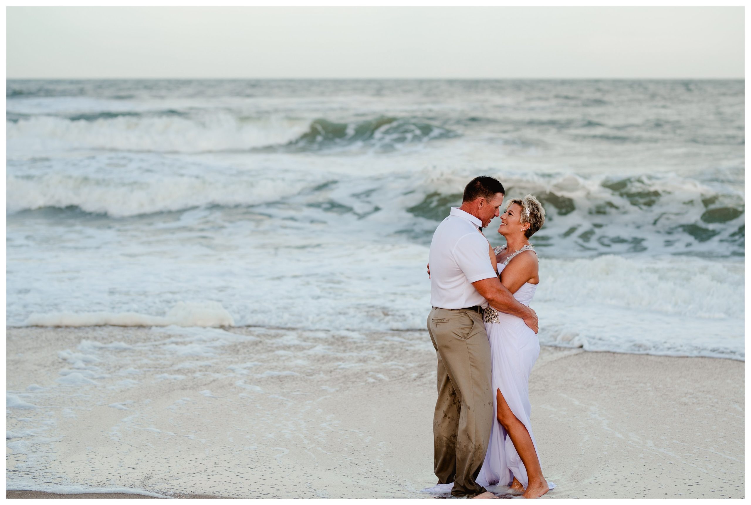 St. Augustine beach wedding couple takes photos along the water with professional candid photographer.