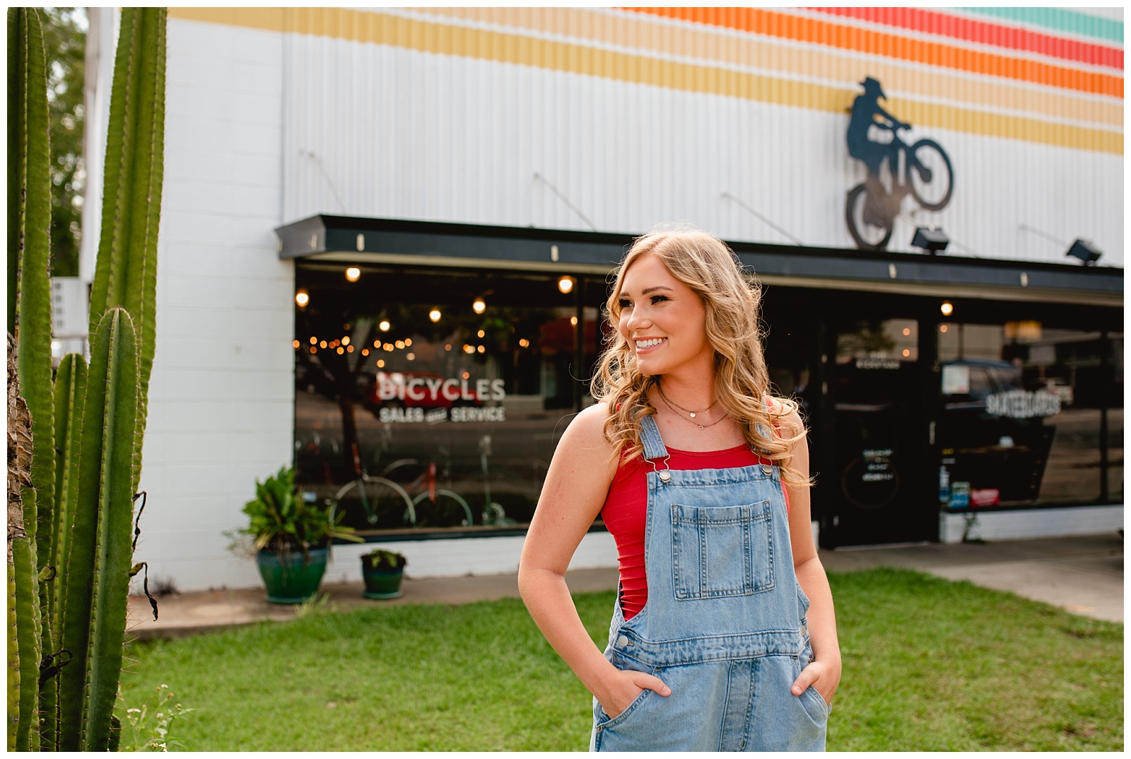 Fun, colorful photos for senior year in front of Bike Shop with girl in overalls.