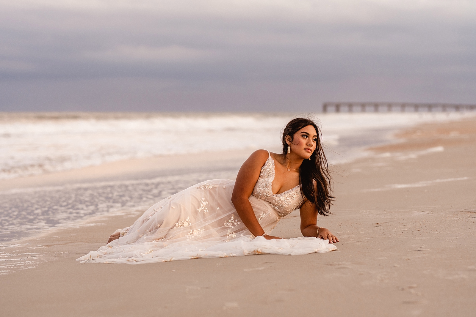 Senior girl laying on beach in long, flowy dress from Alt'rd State. St Augustine professional Senior Photography. Painted Oak Photography.