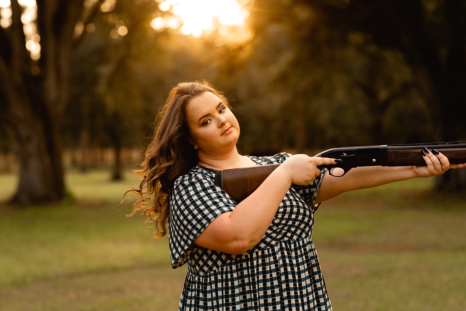 Senior photographer in the south takes photos of country girl with her rifle.