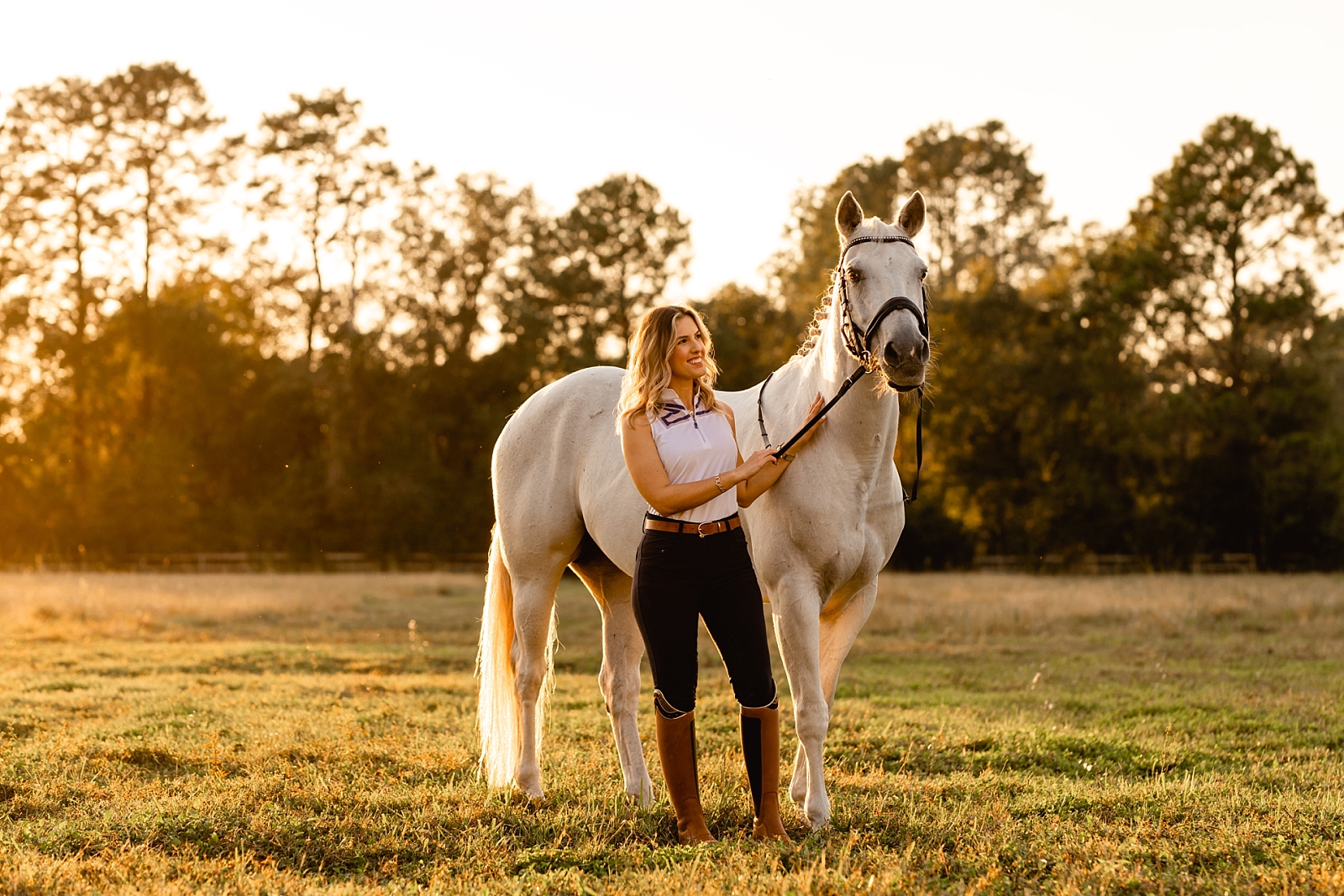 Professional equine photographer near Jacksonville FL takes photos of dressage rider with her grey mare during sunset.