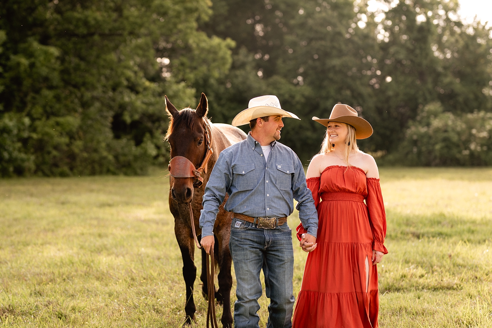 Western couple takes pictures together with roan gelding both wearing cowboy hats near Huntsville, AL.