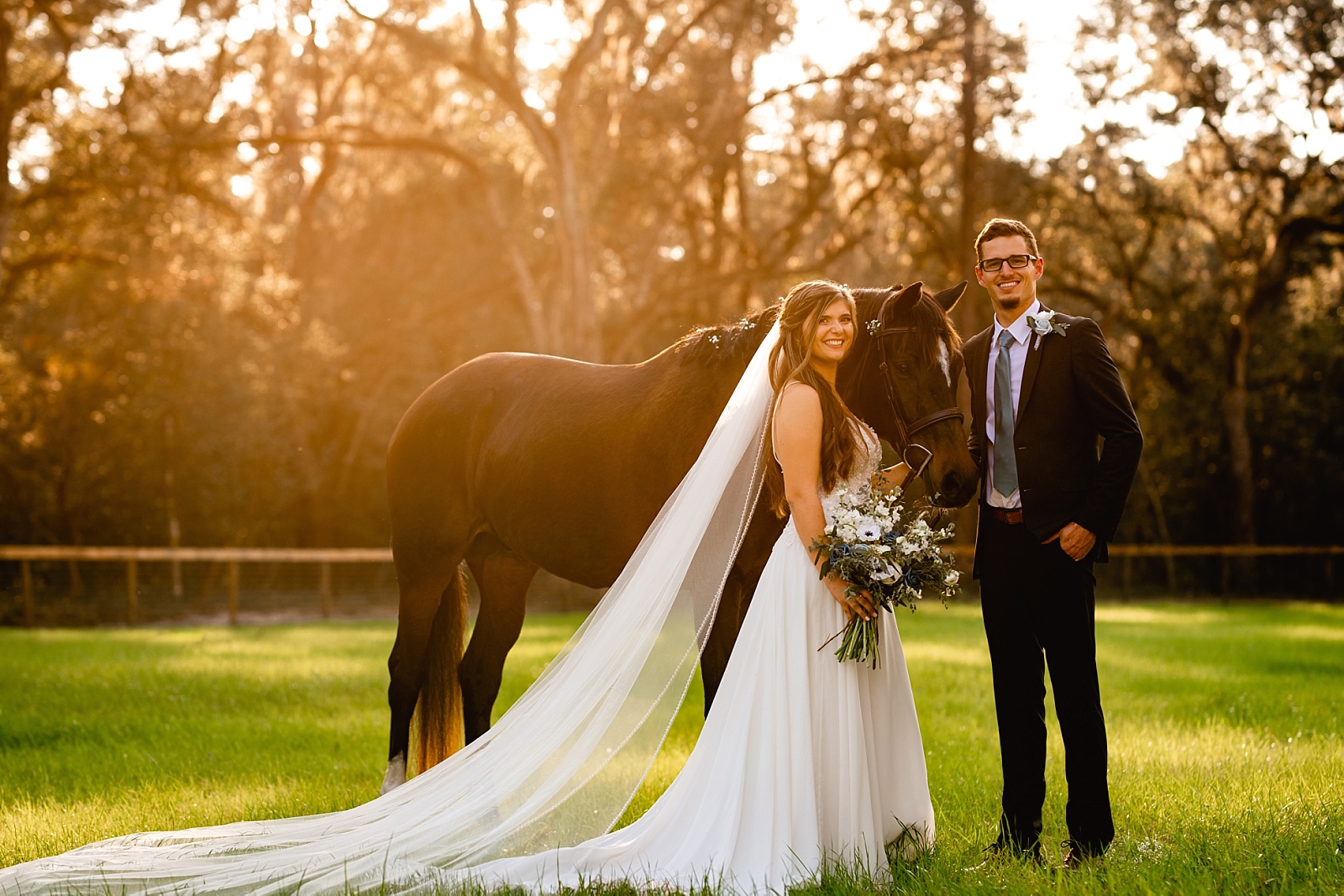 Equestrian bride takes pictures with her horse at her wedding. She put baby's breath in the horses mane. Posing ideas for bride and horse.
