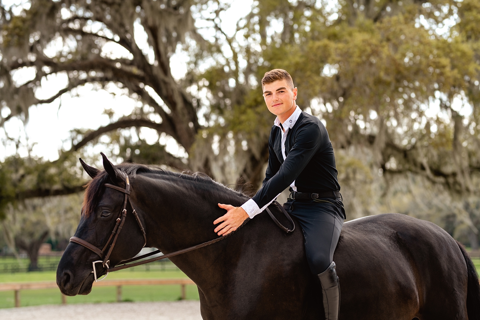 Young rider featured in Sidelines Magazine, Jordan Melfi, takes photos with gorgeous black hunter jumper in Ocala, FL. Male horse and rider session. Horse and rider posing for men.