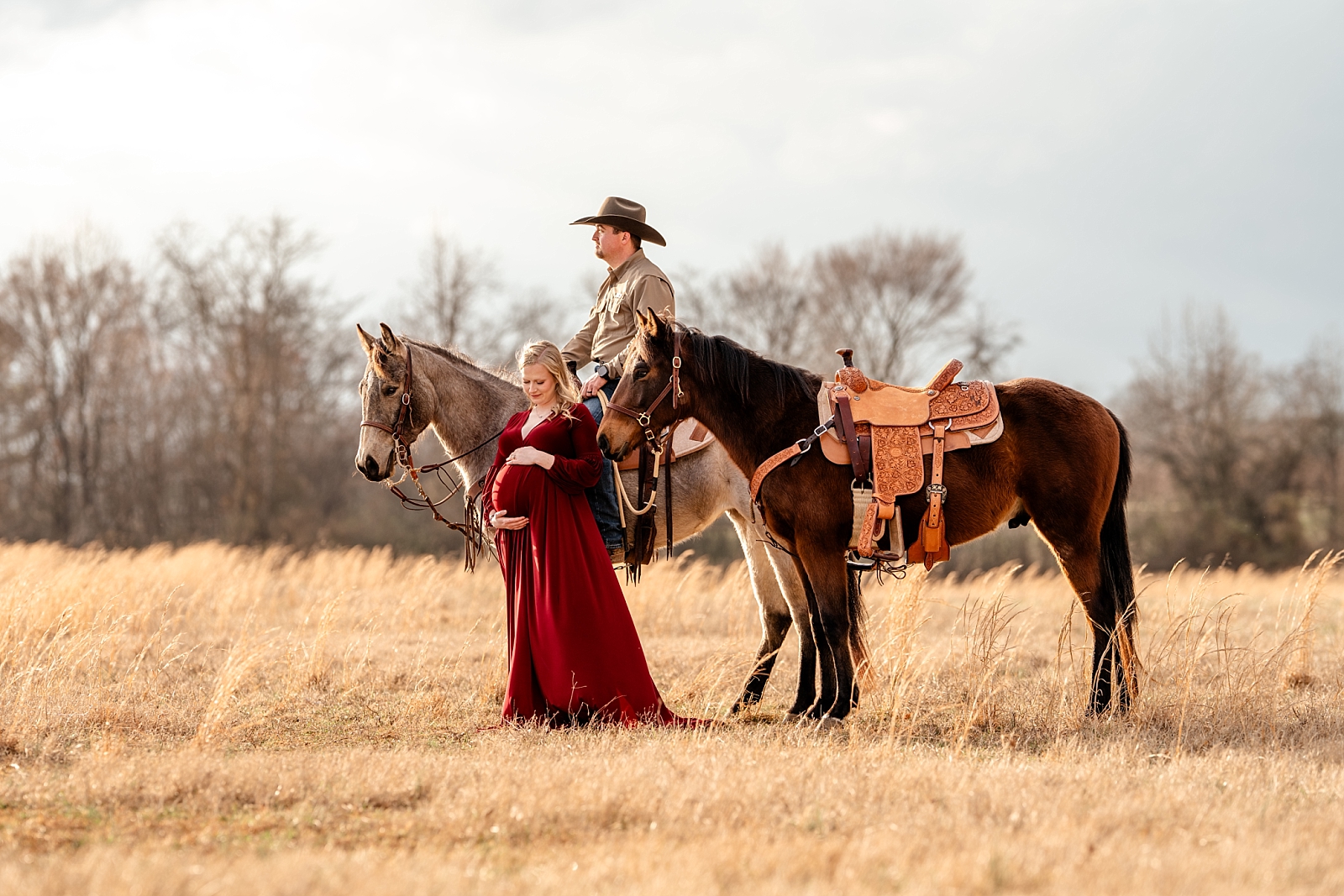 Heather stands with her horse during a maternity session on a farm in Alabama, cradling her baby bump.