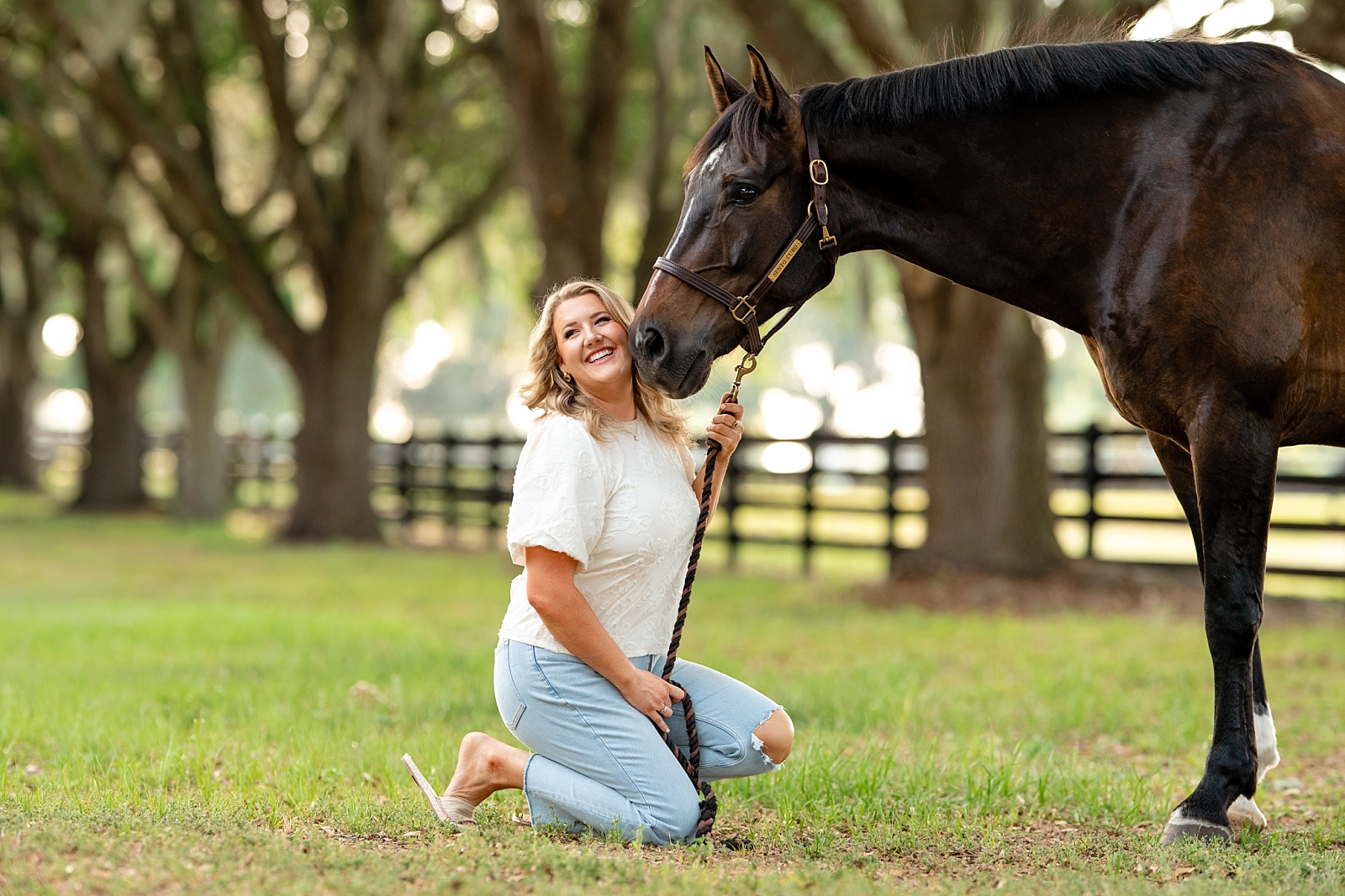 Caroline stands with her dressage gelding, Sento, during a personal equestrian photo session in Ocala, Florida.