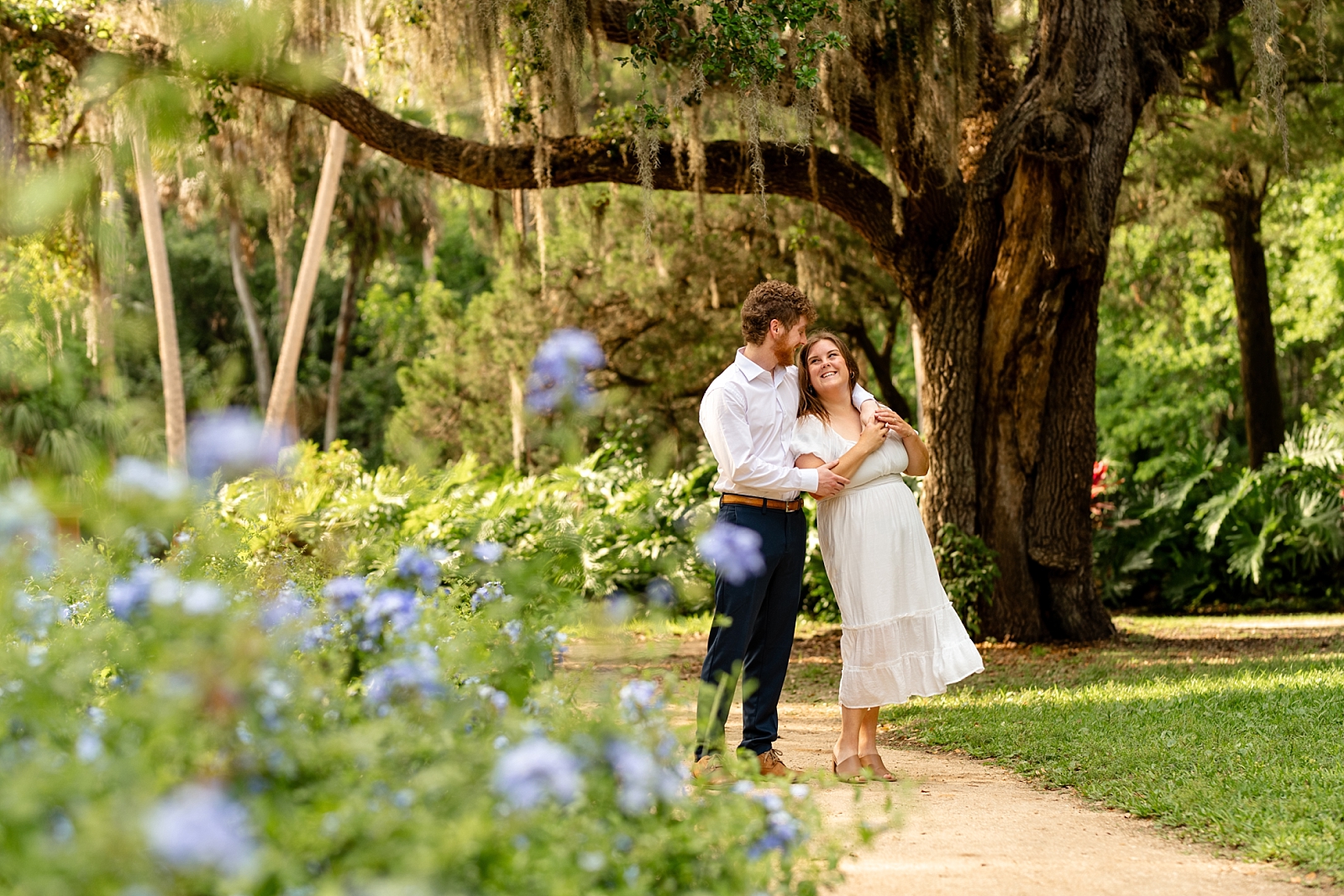 Kristen and Corey pose together in the gardens during their engagement session at Washington Oaks State Park.