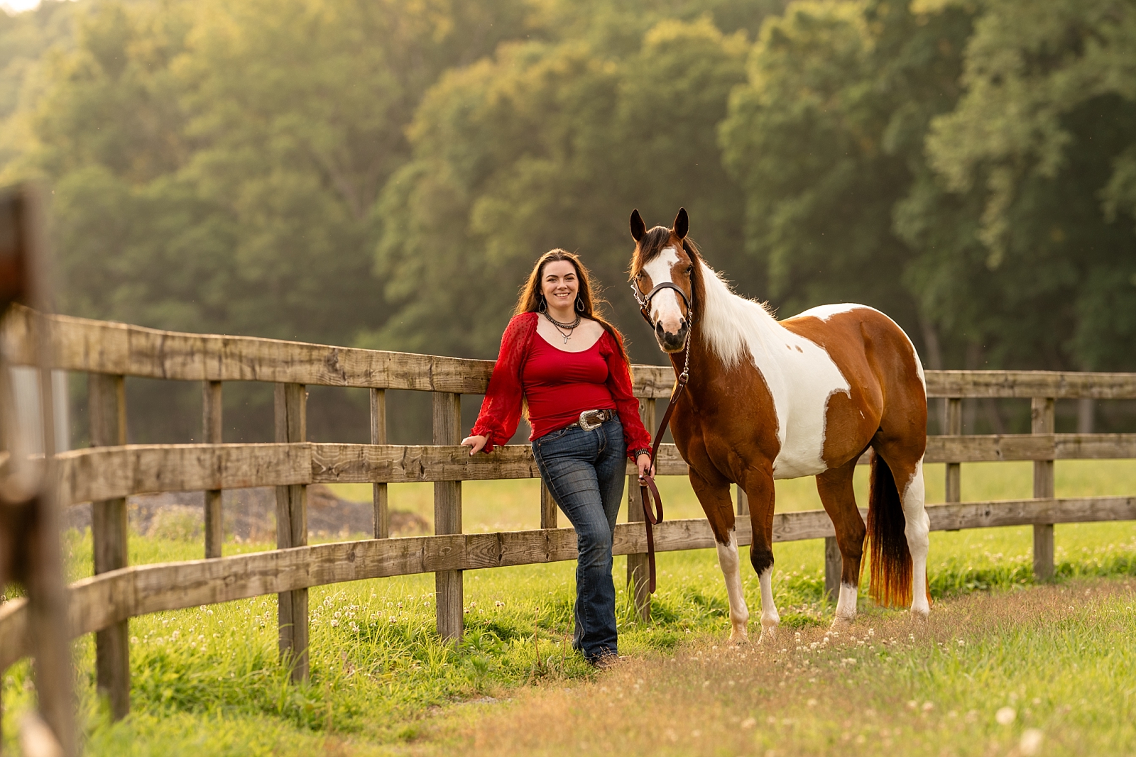 Katie poses with her paint mare Aurora during a golden hour ranch horse session in Woodlawn, Tennessee.